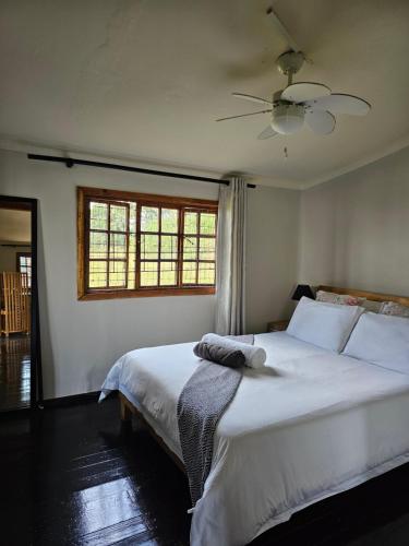 a bedroom with a large white bed and a window at 11-on-RobRoy serenity glamping cabins overlooking the Valley of 1000 Hills in Hillcrest