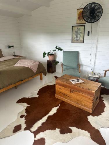 a bedroom with a bed and a table and a chair at Byron Hinterland Rustic Off Grid Cabin in Rosebank