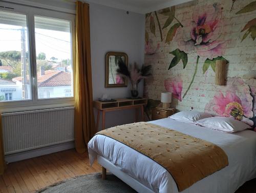 sypialnia z łóżkiem z kwiatową ścianą w obiekcie Villa Saint-Germain w mieście Saint-Georges-de-Didonne