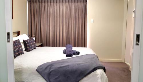 a bedroom with a bed with a towel on it at Urban CBD Perth A GEM 1Bedroom Apartment in Perth