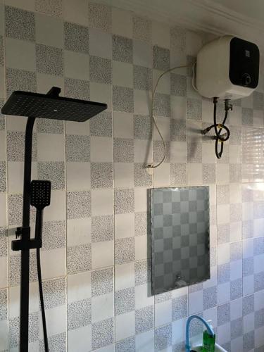 a mirror on a tiled wall in a bathroom at Favour Place in Lagos