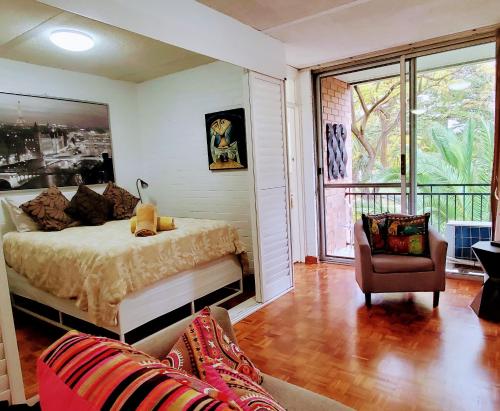 um quarto com uma cama, uma cadeira e uma janela em Quaint & Tranquil Subiaco 1 Bedroom Apartment em Perth