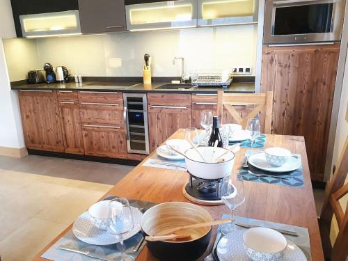 a kitchen with a wooden table with wine glasses on it at Saskya 5 65m2, 2 bedrooms, next to the ski lift in Samoëns