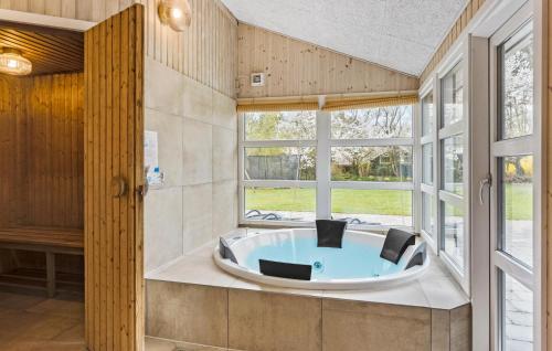 DannemareにあるBeautiful Home In Dannemare With Saunaの窓付きの客室で、バスタブが備わります。
