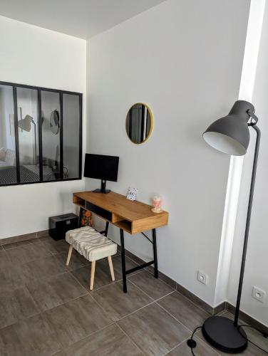 Cette chambre comprend un bureau, une lampe et une chaise. dans l'établissement Spacious Apartment La Ciotat Old Town, à La Ciotat