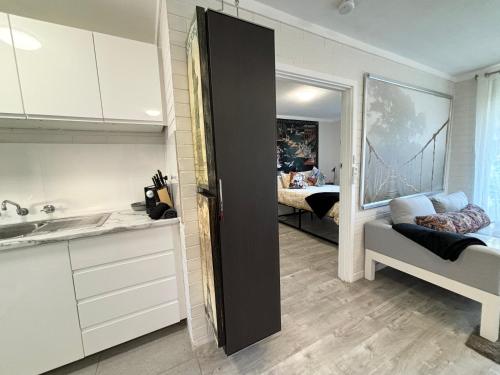 a kitchen with a sink and a room with a bridge painting at Serenity and Comfort in Subiaco 1 Bedroom Unit in Perth