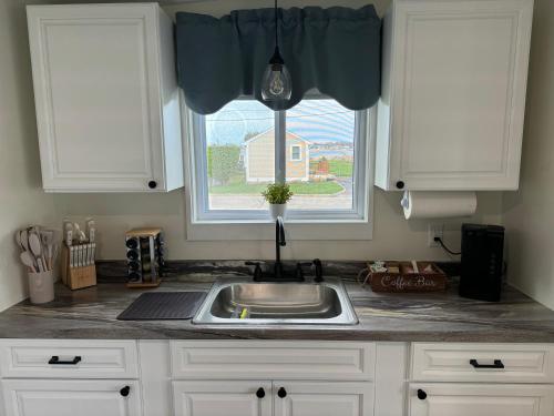 eine Küchentheke mit einem Waschbecken und einem Fenster in der Unterkunft Quaint, family friendly Beach house for 4 in South Dartmouth