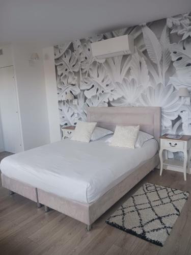 1 dormitorio con cama blanca y pared en Quetzal, en Villars-les-Dombes