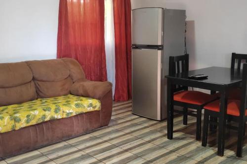 un soggiorno con divano, tavolo e frigorifero di Tranquilo, WIFI y cerca de playas, ArLiz House a Guanacaste