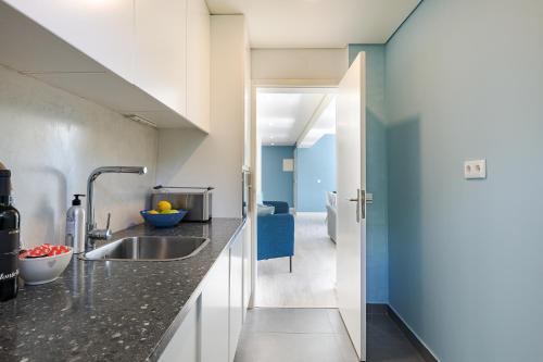 a kitchen with a sink and a blue wall at Casa em Cascais in Cascais