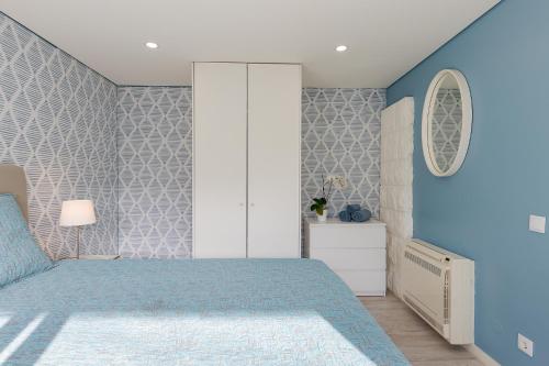 a bedroom with a bed and a blue wall at Casa em Cascais in Cascais
