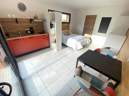 a room with a kitchen and a bedroom with a bed at L'Oustal Des Dômes in Orcines