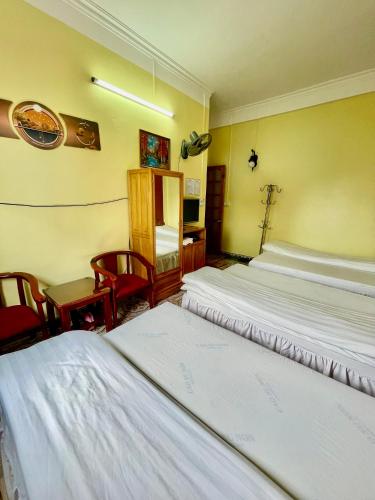 a hotel room with two beds and a desk at Viet Duc Guest House in Sa Pa