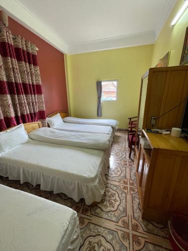 a hotel room with two beds and a desk at Viet Duc Guest House in Sa Pa
