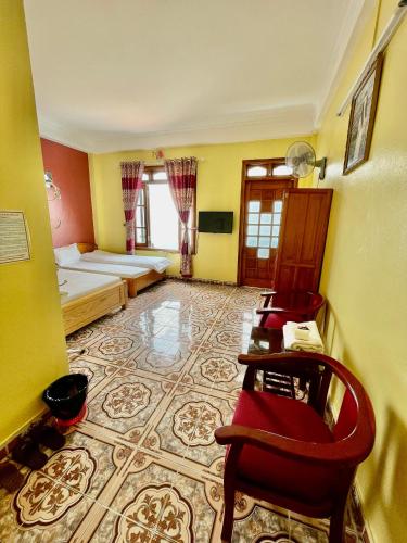 a room with a bed and a table and chairs at Viet Duc Guest House in Sa Pa
