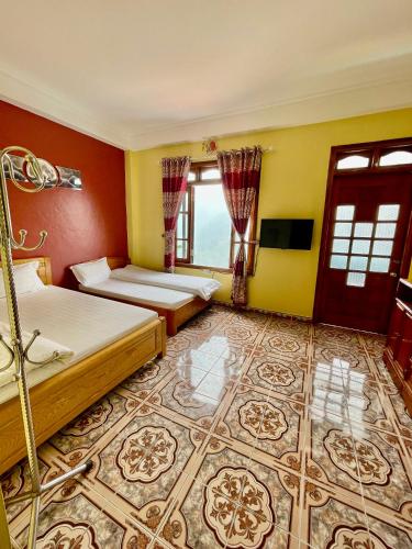 a bedroom with two beds and a tv in it at Viet Duc Guest House in Sa Pa