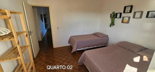 a small room with two beds and a ladder at Centro Guarapari - espaço & conforto - WI-FI in Guarapari