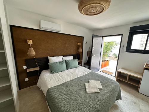 um quarto com uma cama grande e um edredão verde em La maison d'HamiH "Gîte et Chambres d'hôtes em Uzès