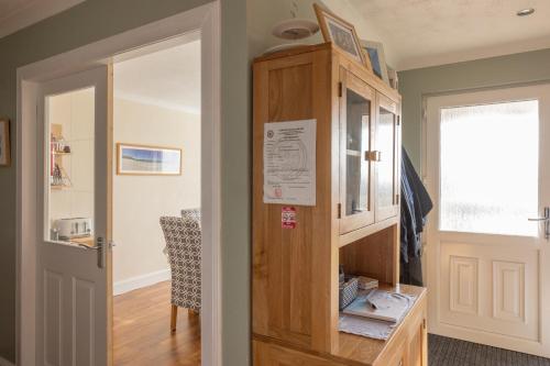 a room with a door and a table and a chair at Ard Buidhe B&B in Daliburgh