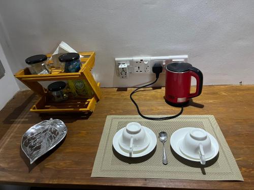 einen Tisch mit Tellern und eine Kaffeemaschine darauf in der Unterkunft Twilight Villas in Rattota