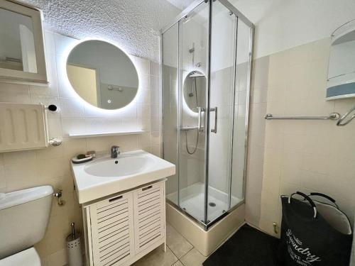 une salle de bain avec une douche, un lavabo et un miroir dans l'établissement Mandelieu Studio rez-de-jardin à Cannes Marina, à Mandelieu-la-Napoule