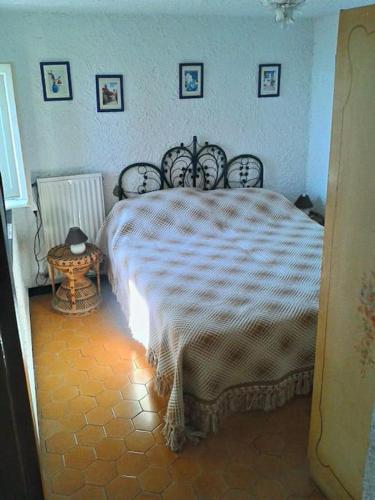a bedroom with a bed with a white comforter at Casa vacanze Dolce Glicine in Bonassola