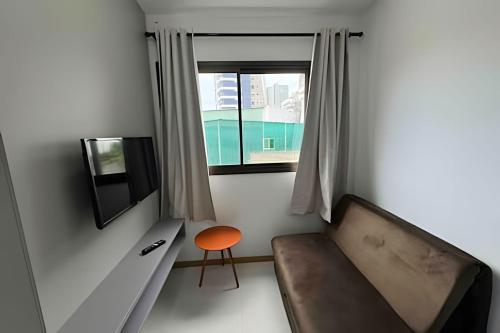 a small room with a couch and a window at Apt equipado com estacionamento in Salvador