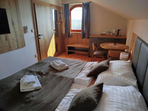 1 dormitorio con 1 cama grande y toallas. en Sklep Víno Strýček en Velké Bílovice
