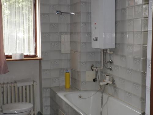 a bathroom with a tub and a toilet and a sink at Pension Arcadia Prague in Prague