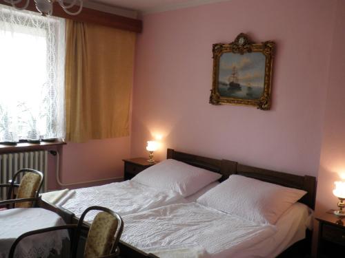 a bedroom with two beds and a picture on the wall at Pension Arcadia Prague in Prague