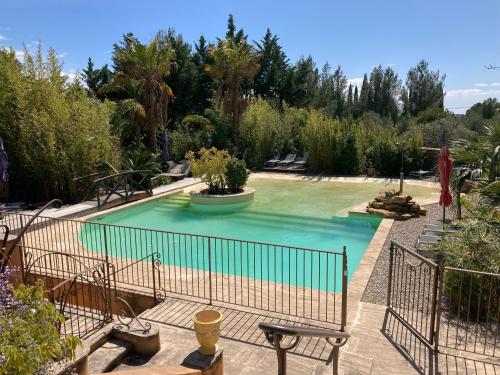 une piscine dans un jardin arboré dans l'établissement L'Arbousier, à Laouque