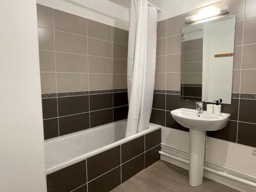 une salle de bain avec un lavabo et une baignoire dans l'établissement Appartement centre-ville Évreux, à Évreux