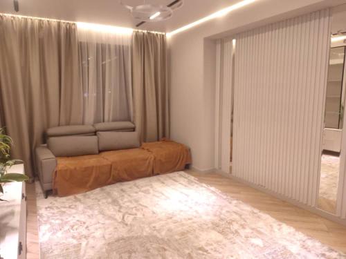 een slaapkamer met een bed en een groot raam bij Элитная квартира со всеми удобствами в центре города Каракол in Karakol