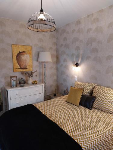 - une chambre avec un lit, une commode et une lampe dans l'établissement La terrasse de Roxane, à Bergerac