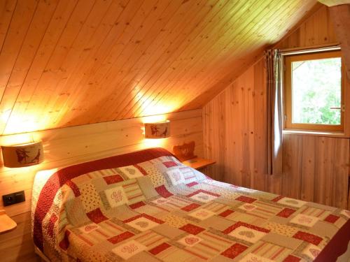 une chambre avec un lit dans une cabane en bois dans l'établissement Appartement Lumineux 3 Pièces avec Balcon, Parking, et Équipements Famille à Châtel - FR-1-676-46, à Châtel