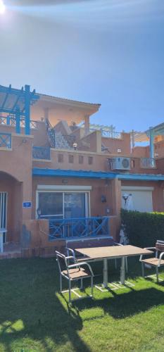 a picnic table and two chairs in front of a building at فيلا توين هاوس مميزة في قرية رويال بيتش رأس الحكمة villa twin house Royal Beach Ras El Hekma in Marsa Matruh