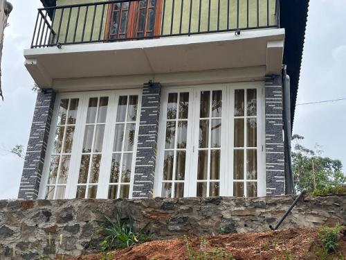 a house with a balcony on top of a stone wall at Twilight Villas in Rattota