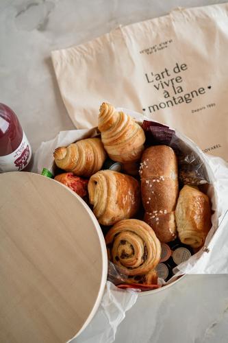un panier de viennoiseries et de croissants dans un sac dans l'établissement Penthouse Le Savoie - LES CHALETS COVAREL, à Val dʼIsère