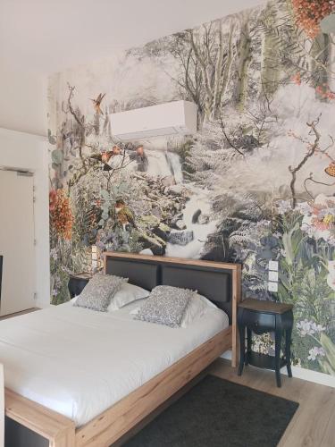 een slaapkamer met een bed en een schilderij aan de muur bij Calao in Villars-les-Dombes