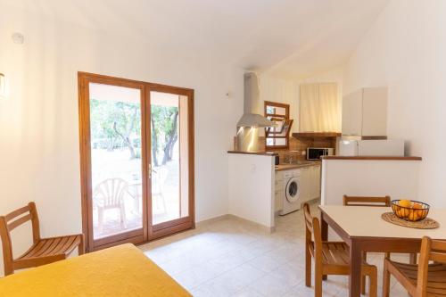 a kitchen with a table and a dining room at Residence Mare e Sole in Taglio-Isolaccio
