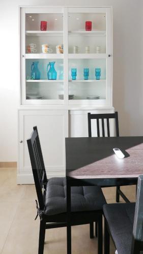 ein Esszimmer mit einem Tisch und blauem Geschirr in einem Schrank in der Unterkunft LOREN'S in Follonica