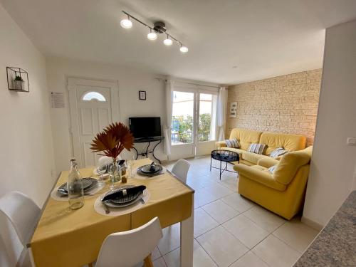 un salon avec une table et un canapé jaune dans l'établissement Gite Thym spa au coeur d'une oliveraie des Corbières, à Saint-Jean-de-Barrou