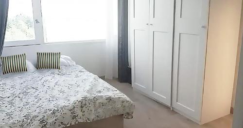 una camera con un letto e una grande finestra di Appartement verdoyant a Noisy-le-Grand