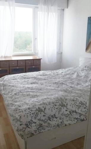 a bedroom with a bed with a floral bedspread at Appartement verdoyant in Noisy-le-Grand