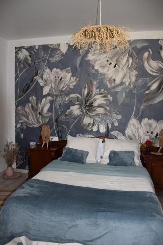 ein Schlafzimmer mit einem großen Bett mit einer blauen und weißen Tapete in der Unterkunft Domaine chez Maurice in Bécheresse