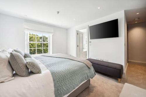 a bedroom with a large bed and a flat screen tv at Oakdale & The Regal at Latchmere Hse in Richmond