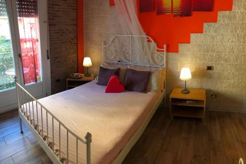 a bedroom with a white bed with two lamps at Europe Station Rooms in Parma