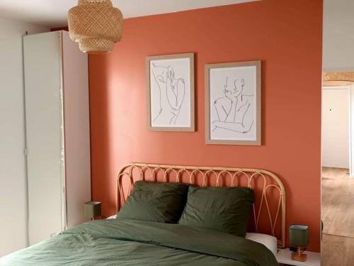 - une chambre avec un mur orange et un lit dans l'établissement Appartement proximité directe Rouen, à Sotteville-lès-Rouen
