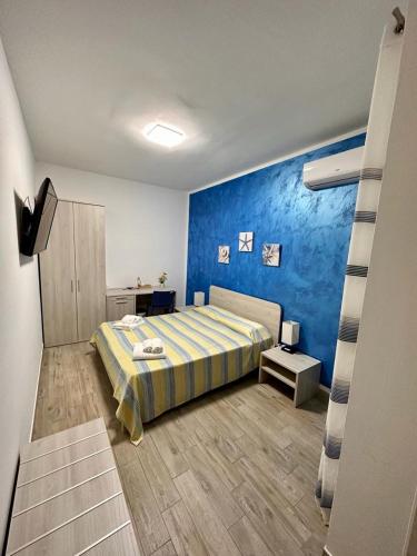 a bedroom with a bed and a blue wall at Affittacamere Villa Ginevra in Gallipoli