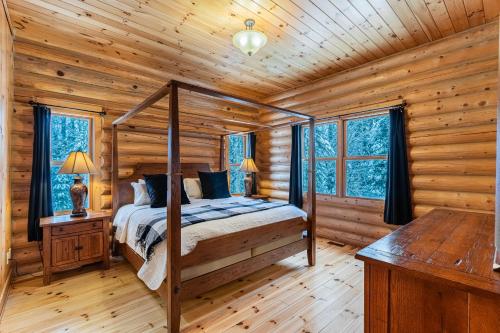a bedroom with a bed in a log cabin at Fiddler Lake Resort Chalet 53 Cerf in Mille-Isles